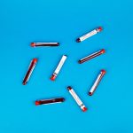 Échantillons de tubes à essai sanguins disposés sur un fond bleu vif