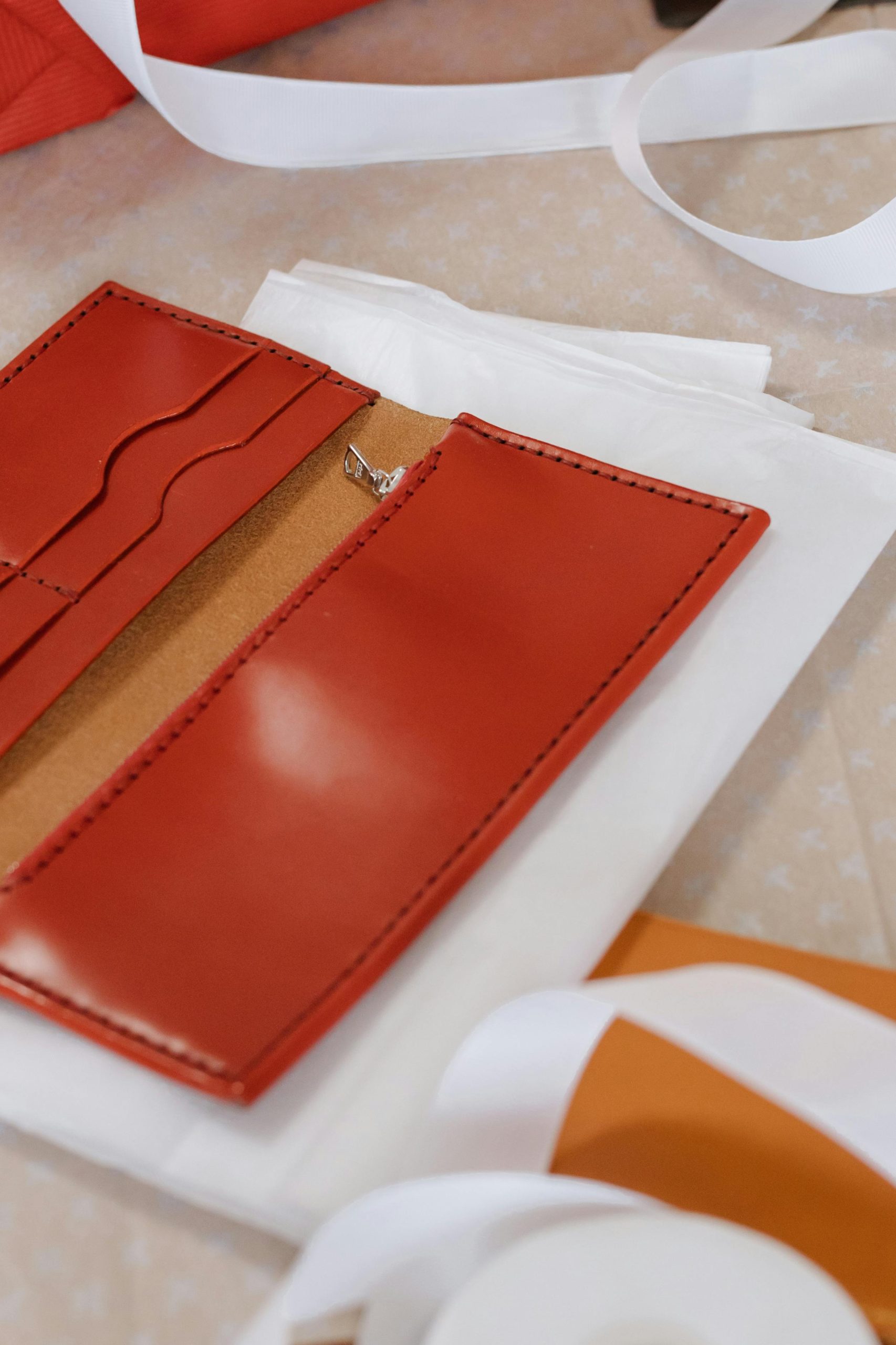 A close-up view of a handcrafted red leather card holder, showcasing craftsmanship. Une vue rapprochée d'un porte-cartes en cuir rouge fait à la main, mettant en avant l'artisanat.