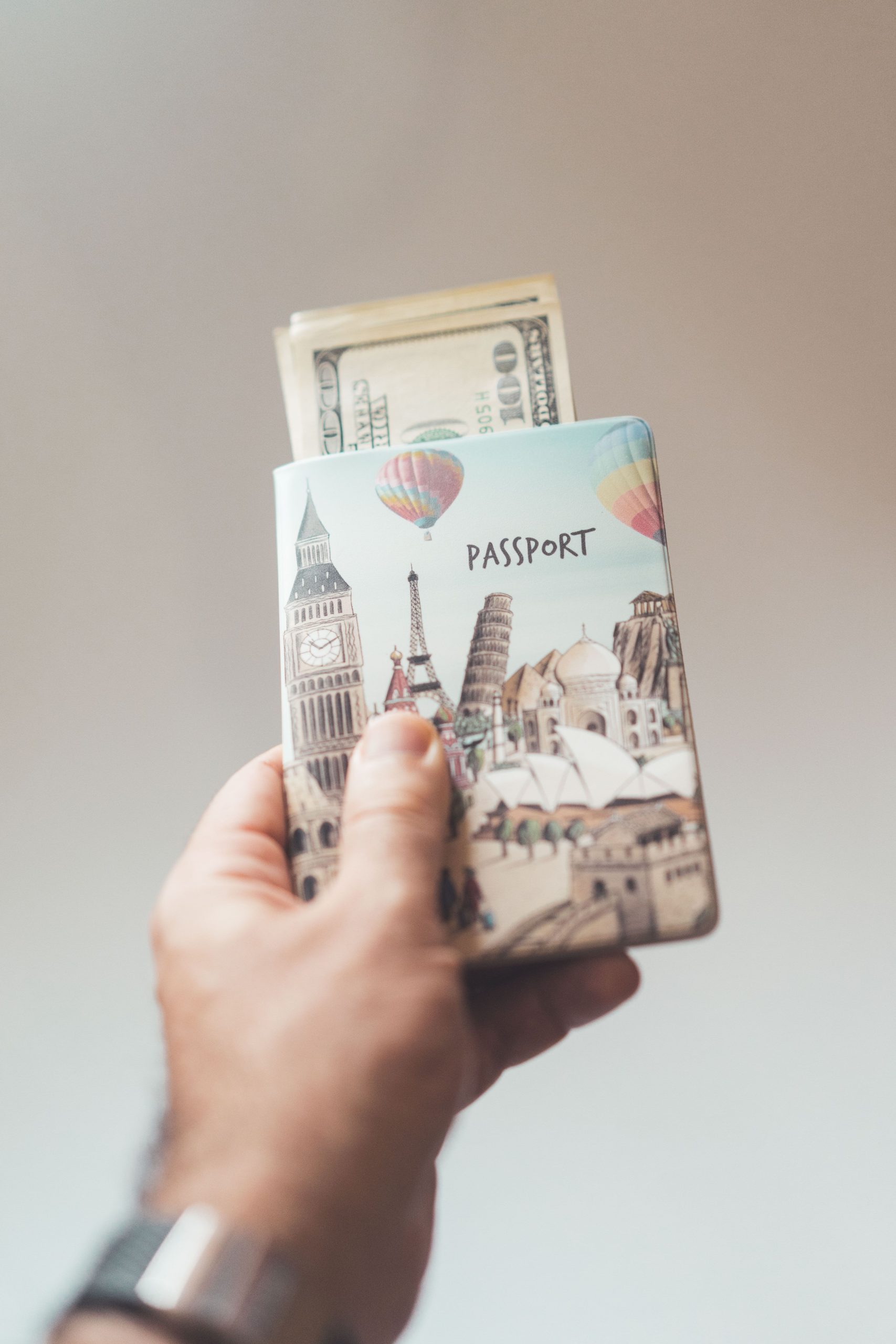 Crop anonymous person showing banknotes with creative passport in hand on beige background Personne anonyme recadrée montrant des billets de banque avec un passeport créatif à la main sur fond beige