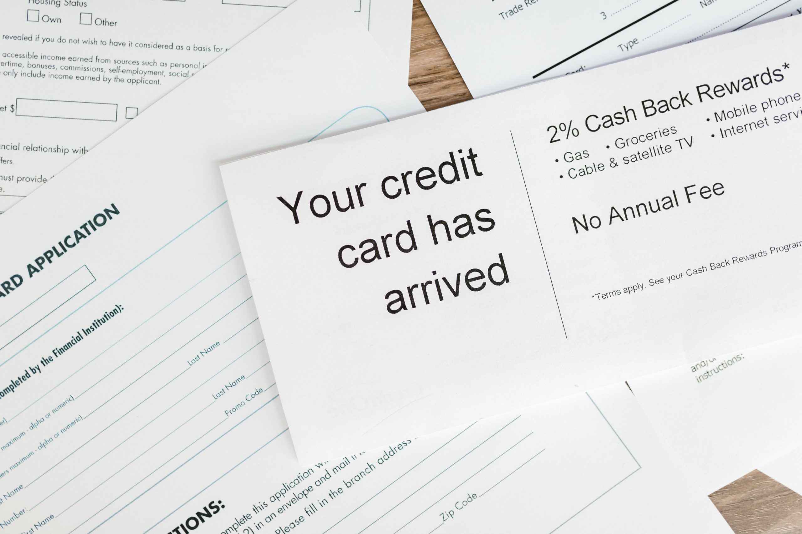 Close-up of a letter announcing the arrival of a credit card amidst financial documents. Gros plan d'une lettre annonçant l'arrivée d'une carte de crédit parmi des documents financiers.