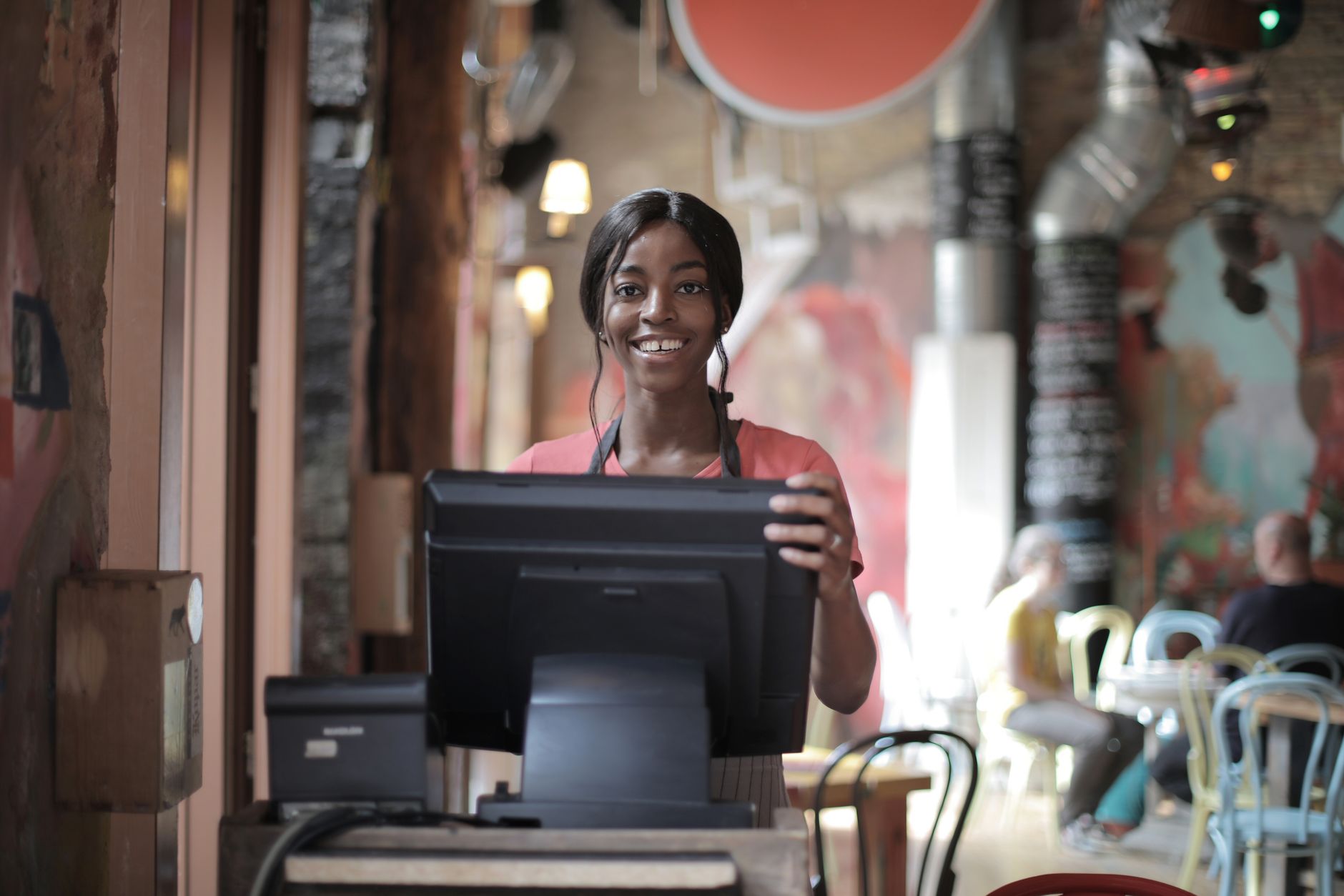 Employée en tenue au comptoir d'un café