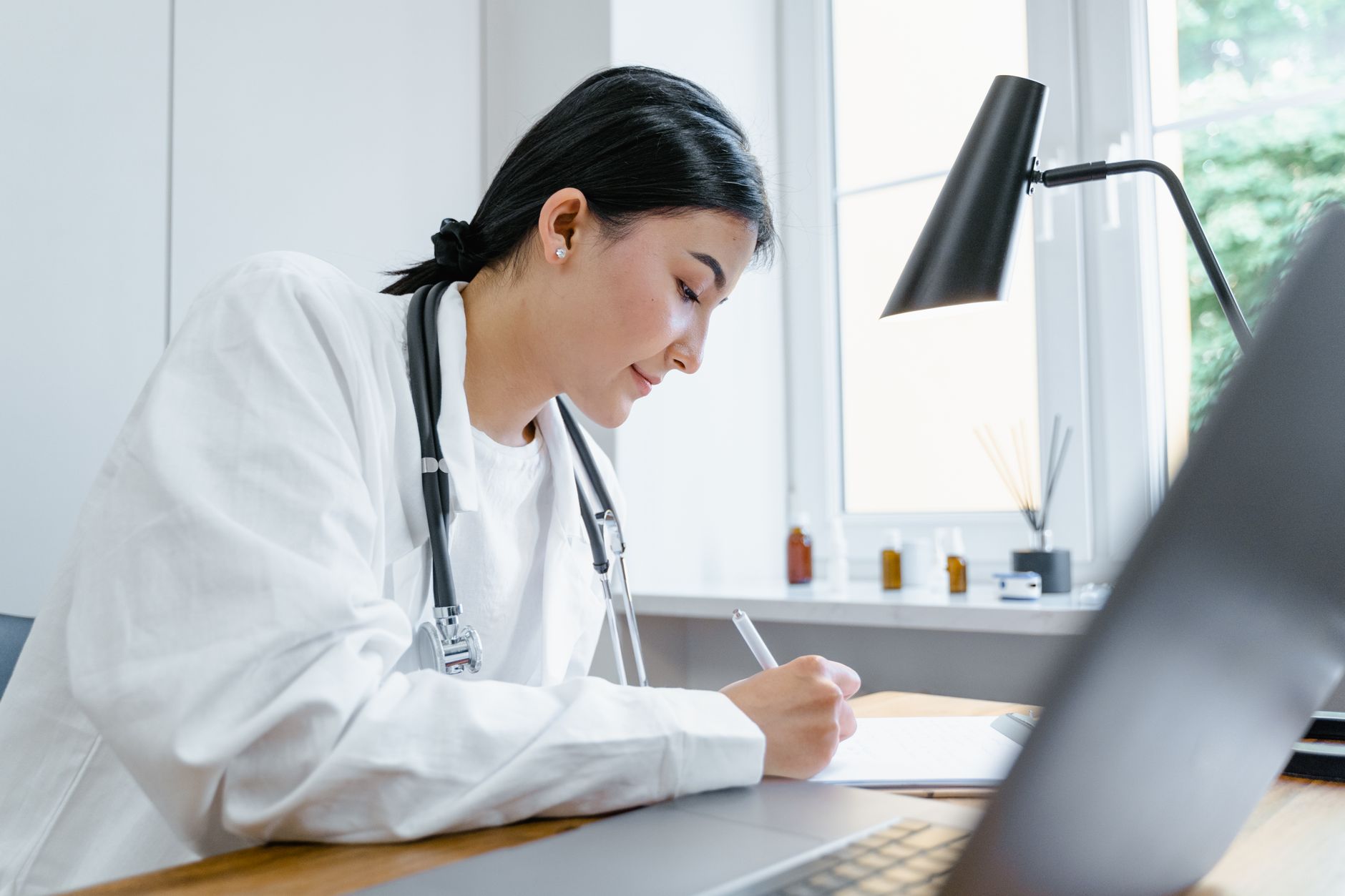 Médecin remplissant un certificat à son bureau