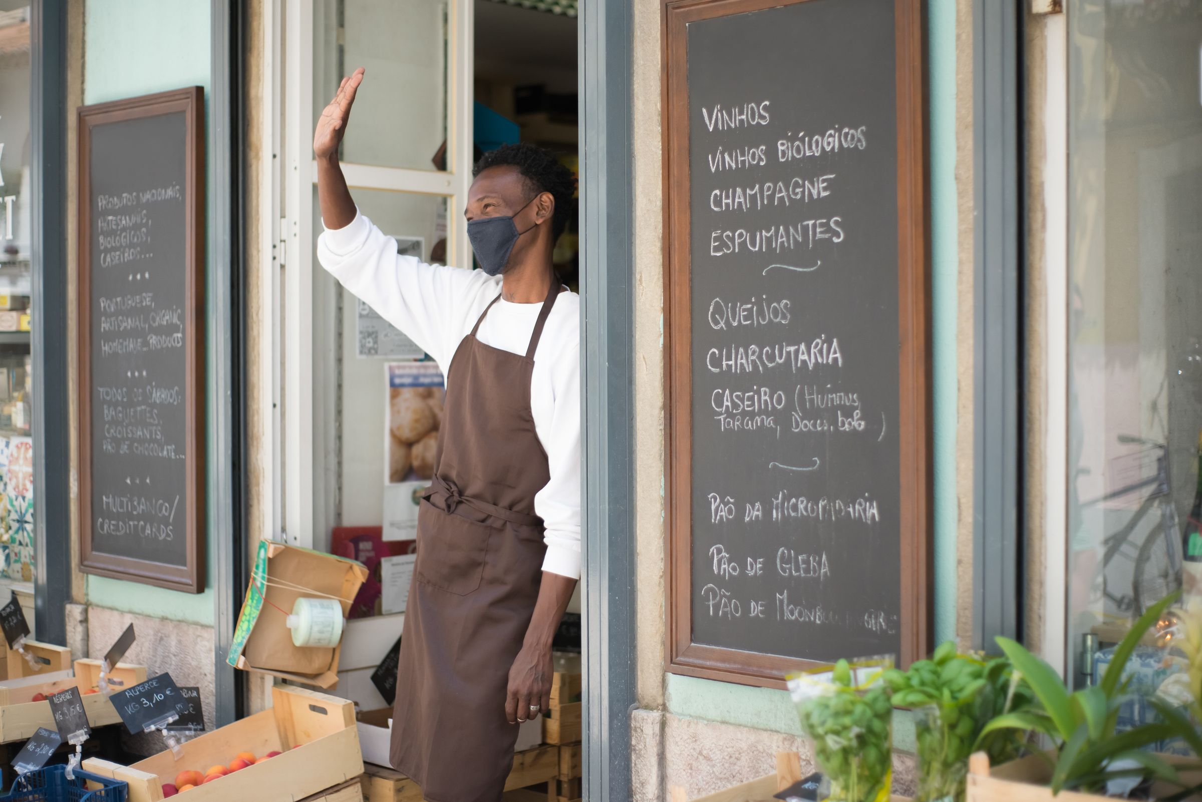 Commerçant en tablier devant sa vitrine