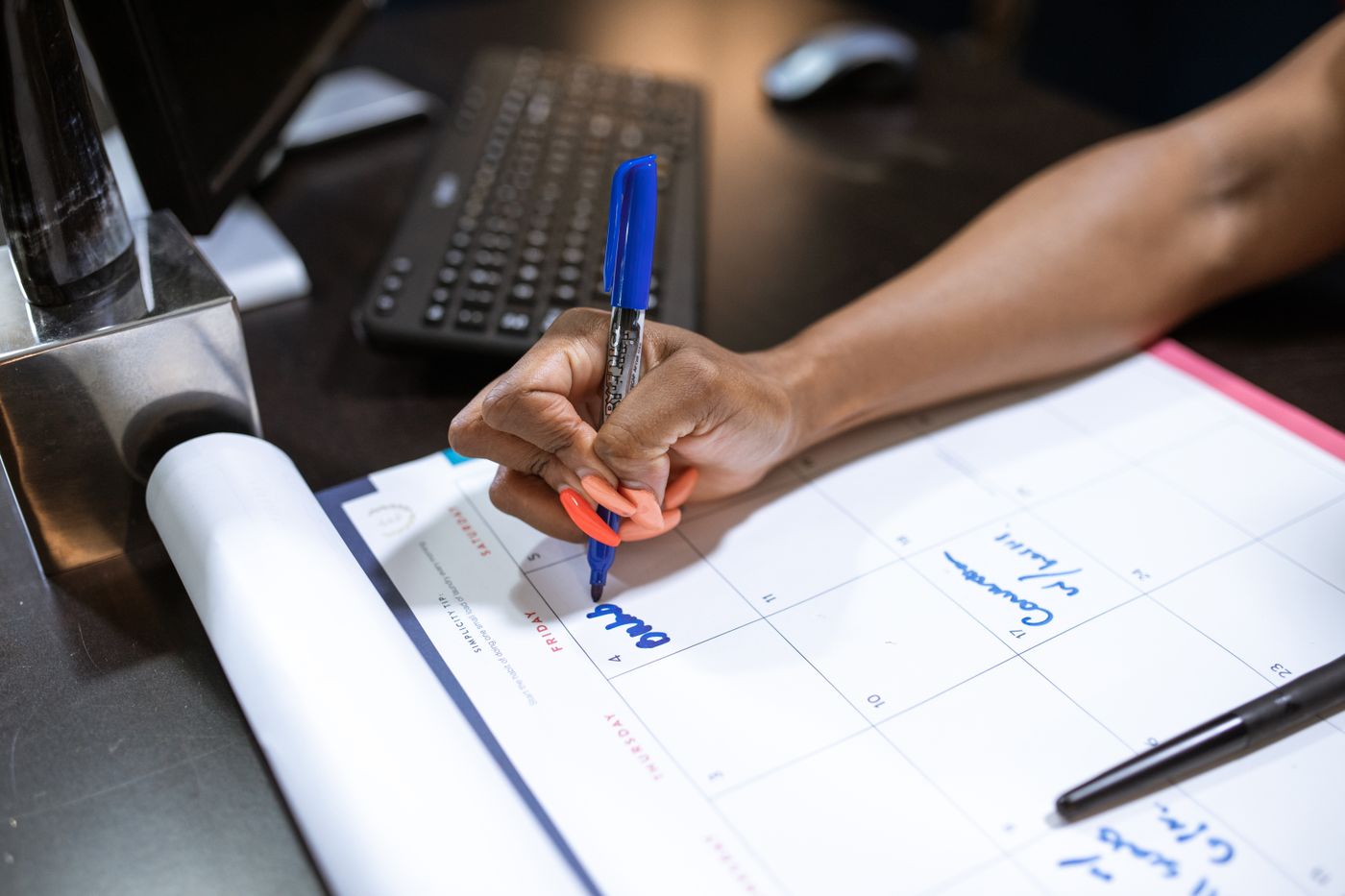 Main qui note une date de congé sur un calendrier